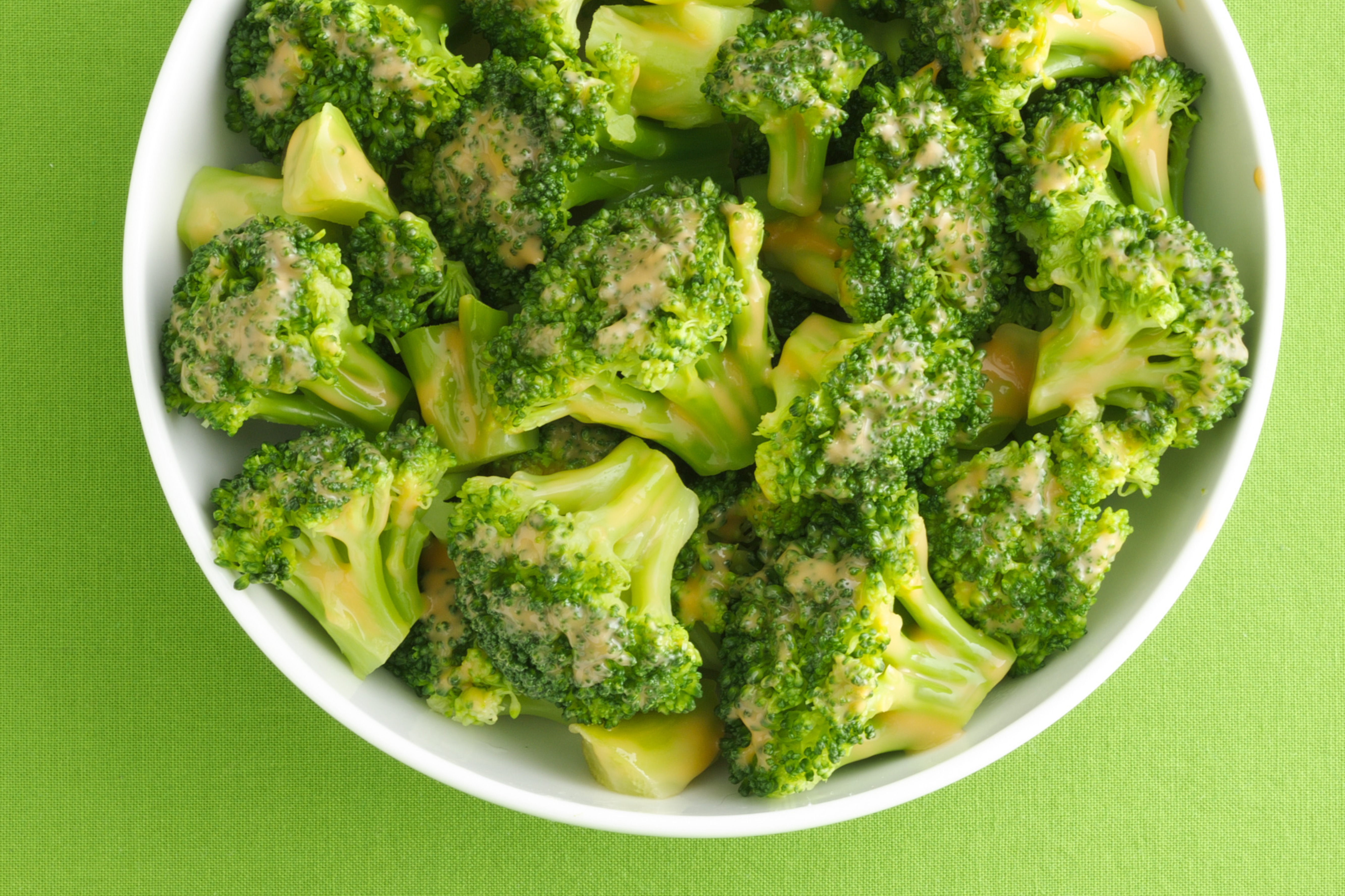 Bowl of broccoli drizzled with cheese